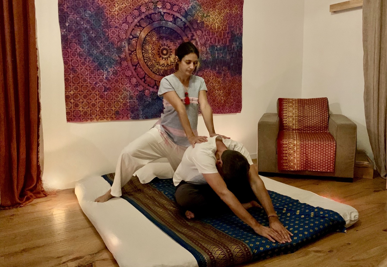 Margo Brunet réalise un étirement de massage thaï traditionnel sur un client, dans le cabinet d'Aix-en-Provence